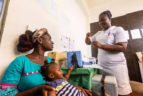 Healthcare staff administering vaccines to children in Ghana.